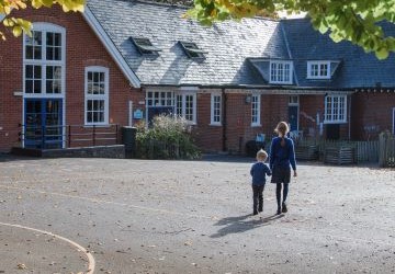 Two schoolchildren walking across a playground