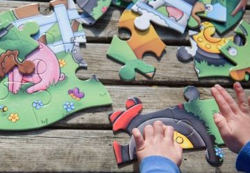A young child's hands doing a jigsaw